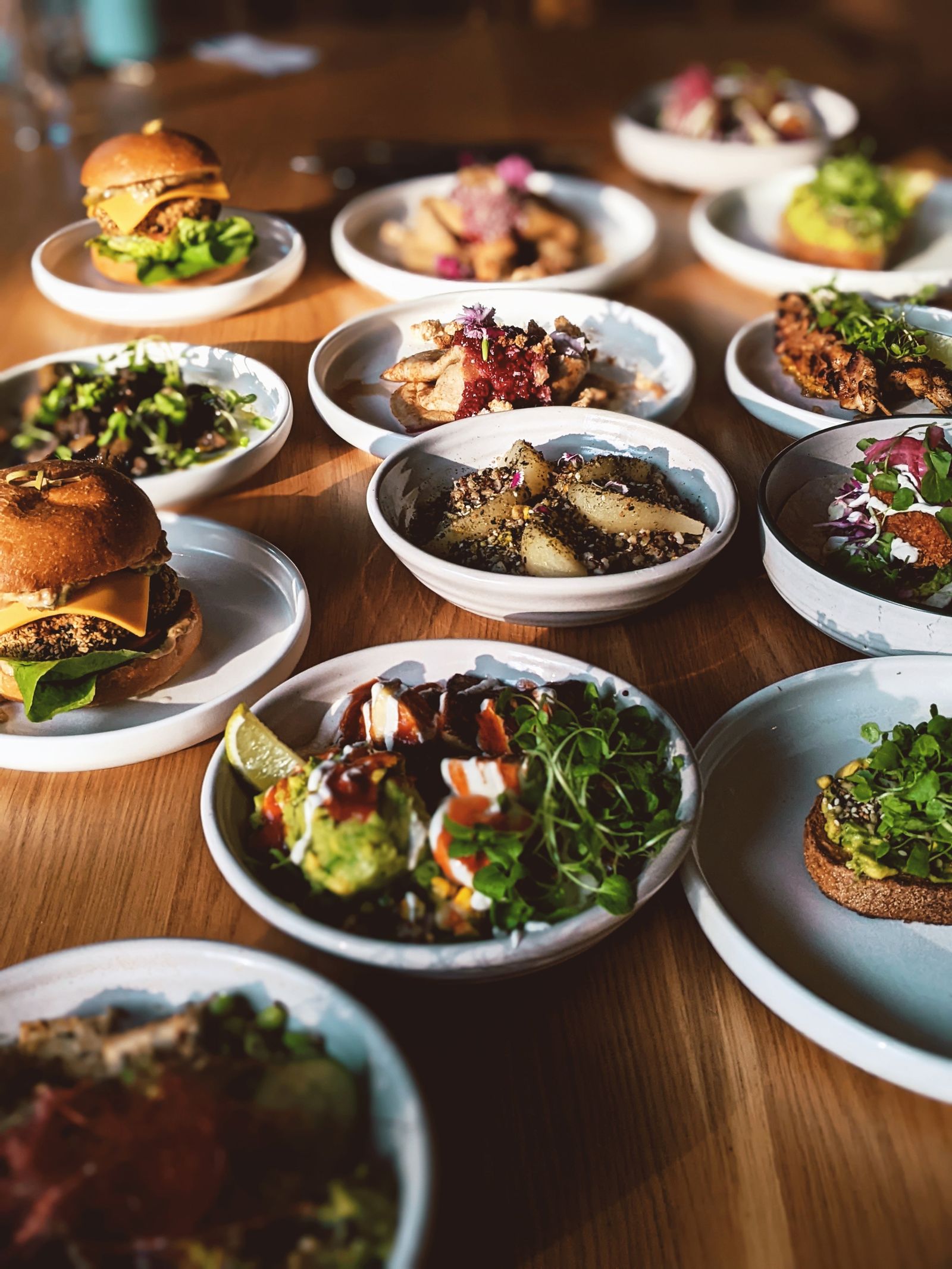 A table covered in Stable dishes — burgers, bowls and toasts